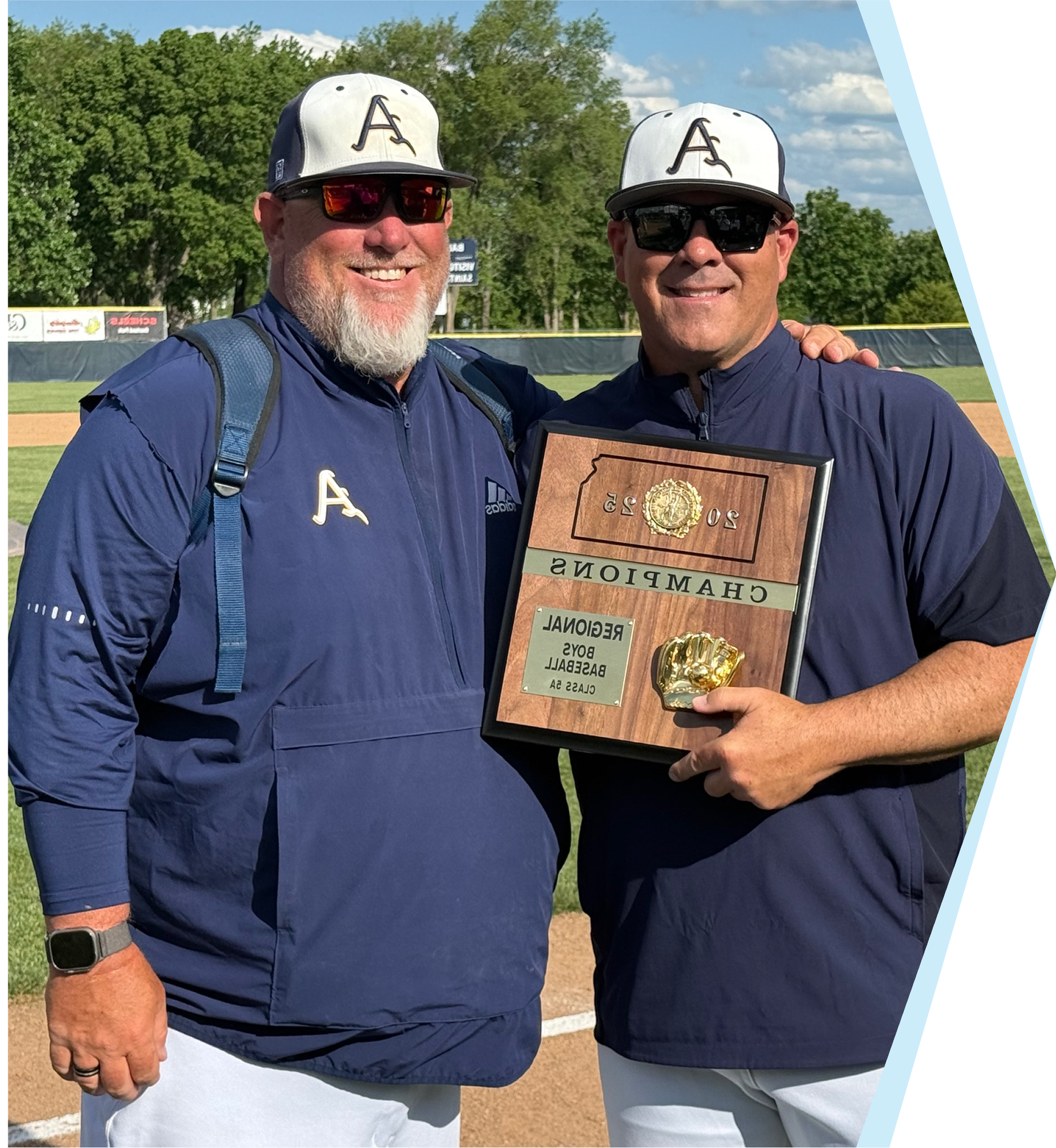 Two coaches with a championship plaque.